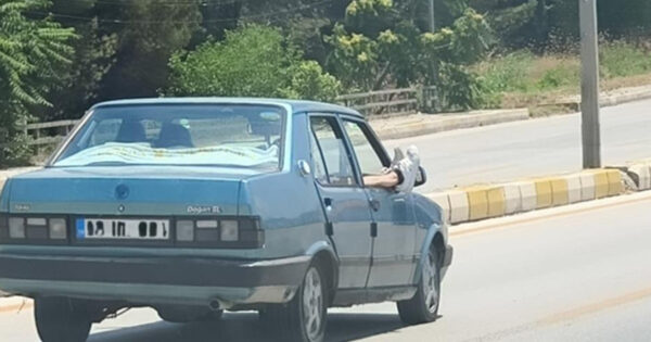 Ayaklarını camdan dışarı çıkartan yolcu trafiği riske attı